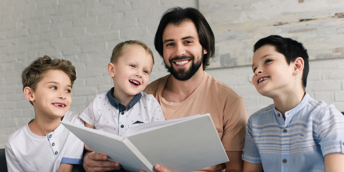 Father reading to three children